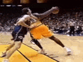 a couple of basketball players are playing a game of basketball .