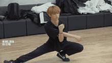 a young man is squatting on a wooden floor with the date 06 dec 2018 at 3:12 pm