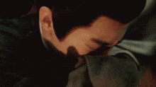 a close up of a man covering his face with his hands