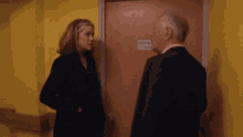 a man in a suit is hugging a woman in front of a door that has a sign that says information room