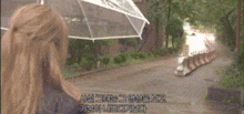 a woman is holding an umbrella in the rain while walking down a sidewalk .