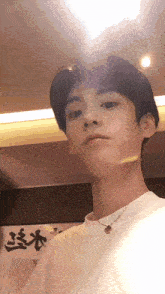a young man taking a selfie in front of a sign that says ' chinese ' on it