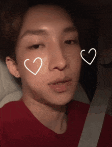 a close up of a person 's face with two hearts drawn on it
