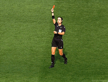 a female referee holds up a red card in front of a scoreboard that says concacaf nations league
