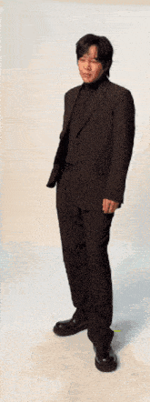 a man in a suit and black turtleneck is dancing .