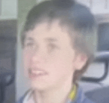 a blurry picture of a young boy 's face with a yellow collar .