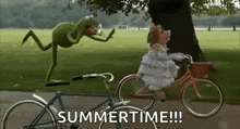 kermit the frog is riding a bike next to a muppet on a bicycle .