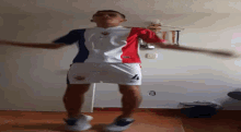 a man wearing a red white and blue shirt and shorts with the number 4 on them