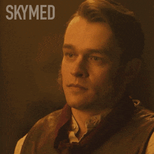 a man with a scarf around his neck and the word skymed above him