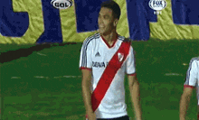 a soccer player wearing a bbva jersey is standing on a field