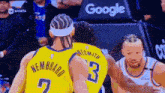 two basketball players are talking to each other during a game .