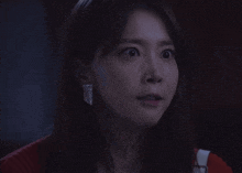 a woman with a surprised look on her face wearing a pair of earrings