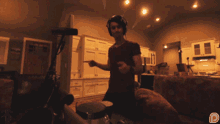 a man wearing headphones is playing a drum set in a dark room