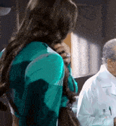 a woman in a green jacket is standing next to a man in a white coat