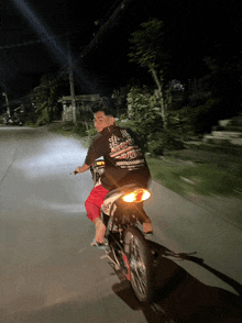 a man riding a motorcycle with a shirt that says ' racing '