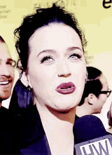 a woman talking into a microphone that says lw