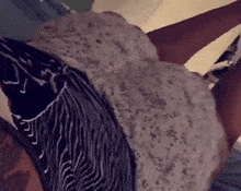 a woman is laying on a bed wearing a striped shirt and a white dress .