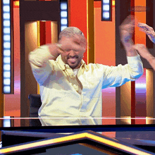 a man in a yellow shirt is dancing in front of a sign that says passmasters