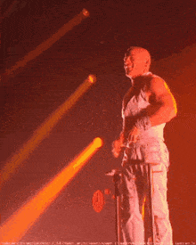 a man is standing on a stage with a microphone and a spotlight shining on him