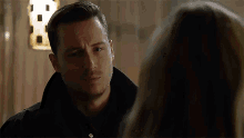 a man and a woman are looking at each other in a dark room .