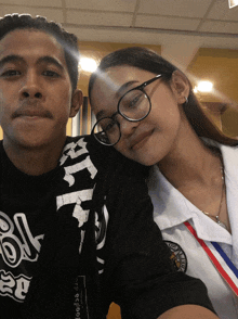 a man and a woman are posing for a picture and the man is wearing a black shirt that says " bk " on the front