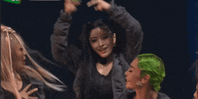 a woman with green hair is dancing in front of a green background