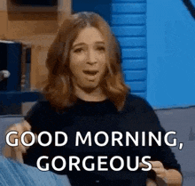 a woman is sitting on a couch with her mouth open and says `` good morning , gorgeous '' .
