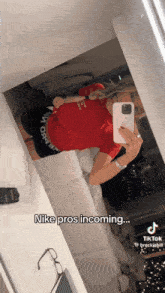 a woman is taking a selfie in front of a mirror with the words nike pros incoming
