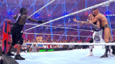 two men are wrestling in a wrestling ring while a referee looks on .