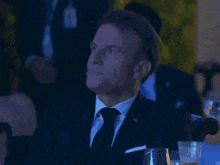 a man in a suit and tie sits with his eyes closed