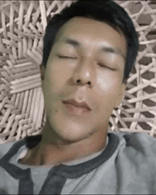 a man with his eyes closed is laying on a wicker couch