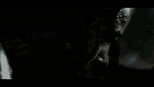 a white car is driving down a dirt road in the dark