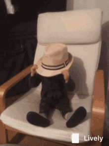 a child sitting in a chair with a hat on his head