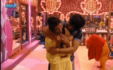a man is carrying a woman in a room with a sign that says live channel on it