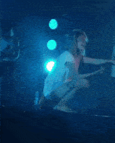 a woman in fishnet stockings is jumping in the air on stage