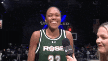 a female basketball player wearing a green jersey with the number 23 on it