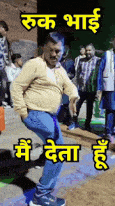 a man in a yellow shirt is dancing in front of a group of people with a sign that says " rukh bhai "