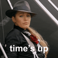 a woman wearing a hat and tie with the words time 's up behind her