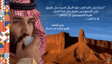 a man in a keffiyeh is smoking a cigarette in front of a desert landscape