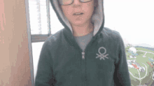 a person wearing a green hoodie with a white ox on the front