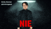 a man in a black jacket is standing in front of a sign that says nie