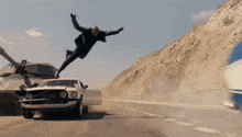 a man is jumping over a car that has a license plate that says ' volvo ' on it