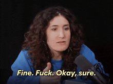 a woman with curly hair says fine fuck okay sure in front of a microphone