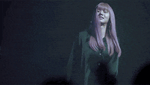 a woman with pink hair is wearing a green shirt