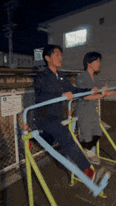a man and a woman are doing exercises in front of a fence with a sign that says e.