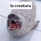 a seal with its mouth open and the word la creature on top of it