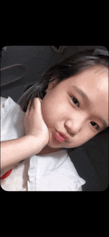 a young girl with her hand on her chin