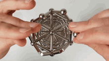 a person is playing with a metal toy that looks like a snowflake