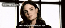 a woman is standing in front of a window and talking to a dog while you cry .