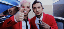 two men in red suits are giving a thumbs up sign